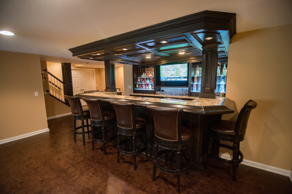 large home bar in basement with granite countertops