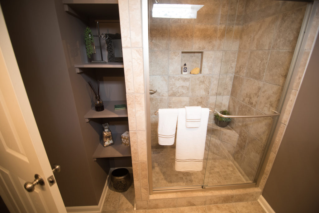 spare bathroom in basement with vinyl tile and custom sheliving