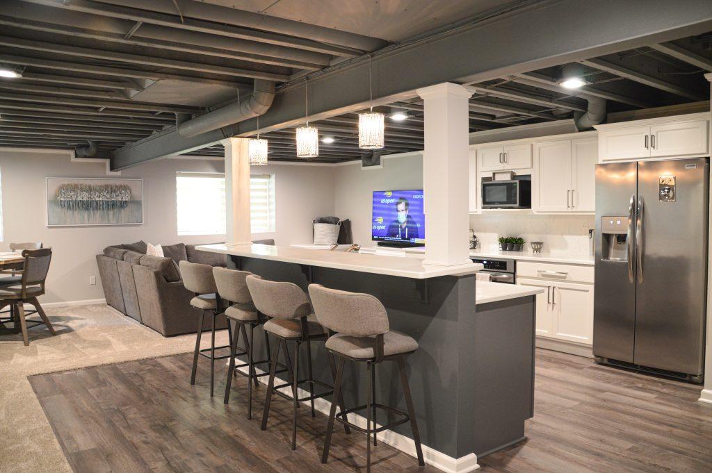 Finished basement bar rea with seating for four, overlooking the living room area.