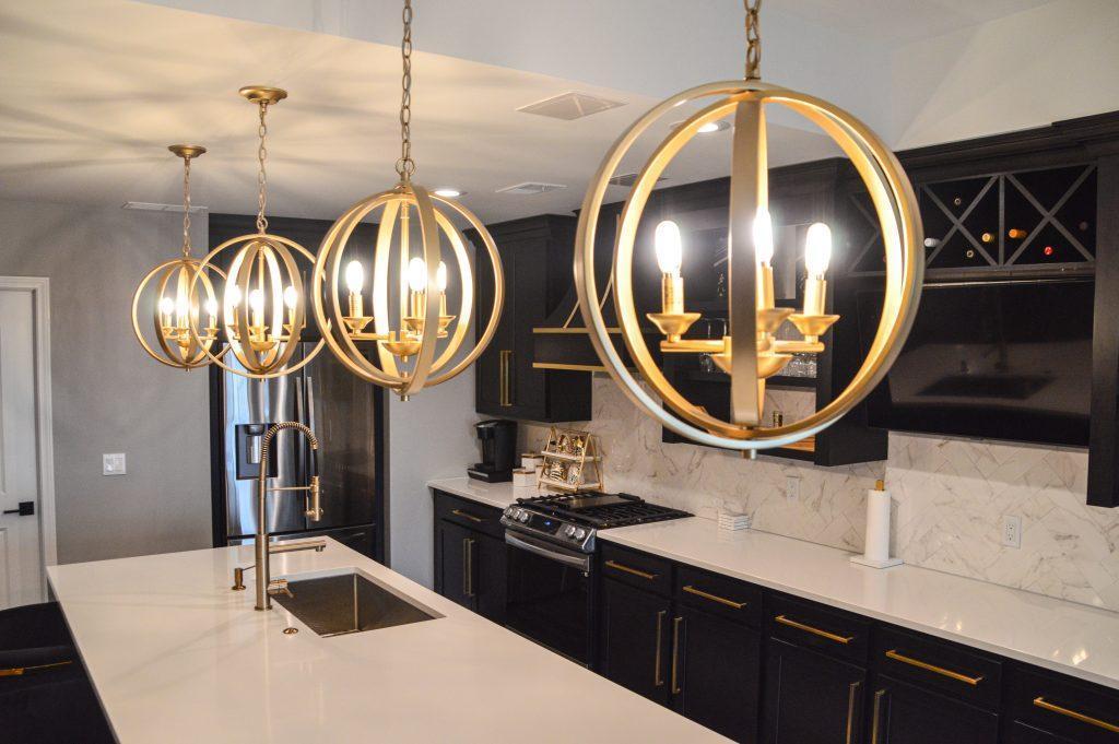 Closeup of round hanging gold lights over the kitchen counter.