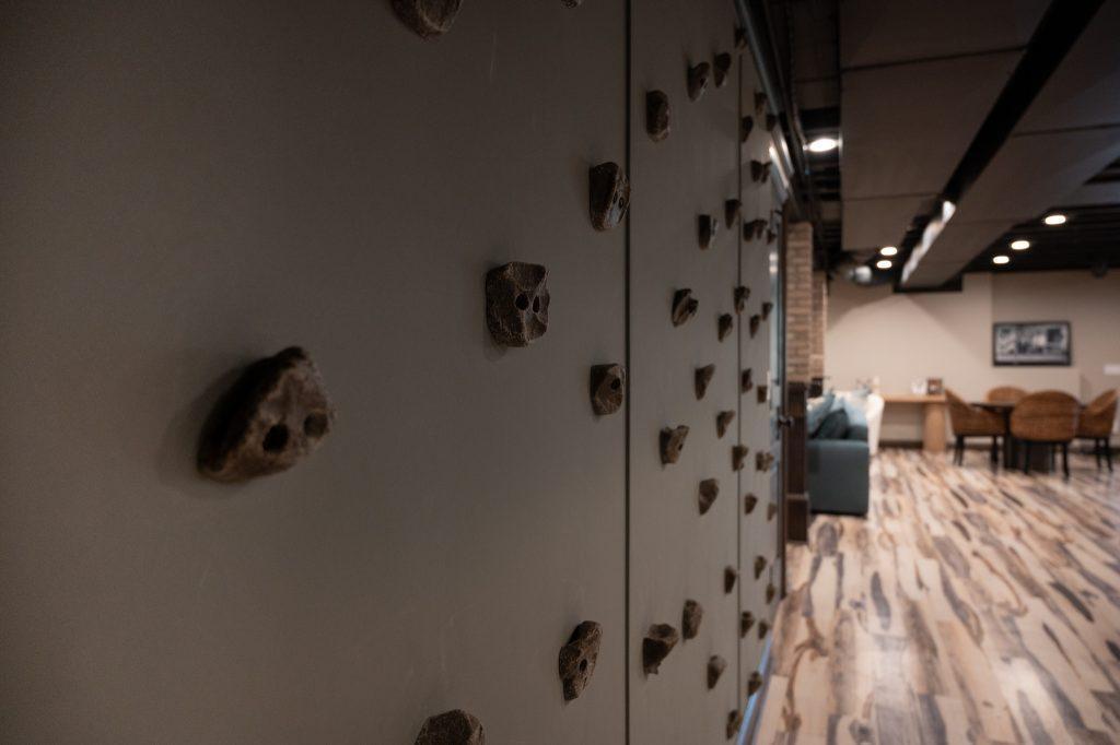 Custom build rock climbing wall in the hallway of a finished basement.