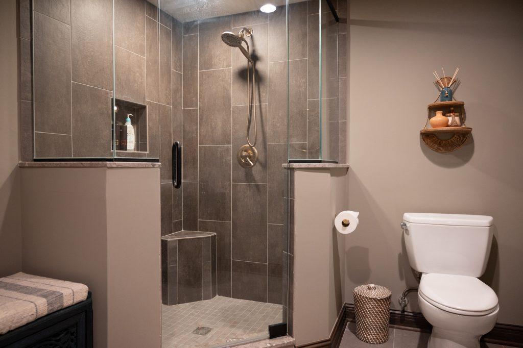 Closeup view of walk in shower in the bathroom with large tile and glass door.