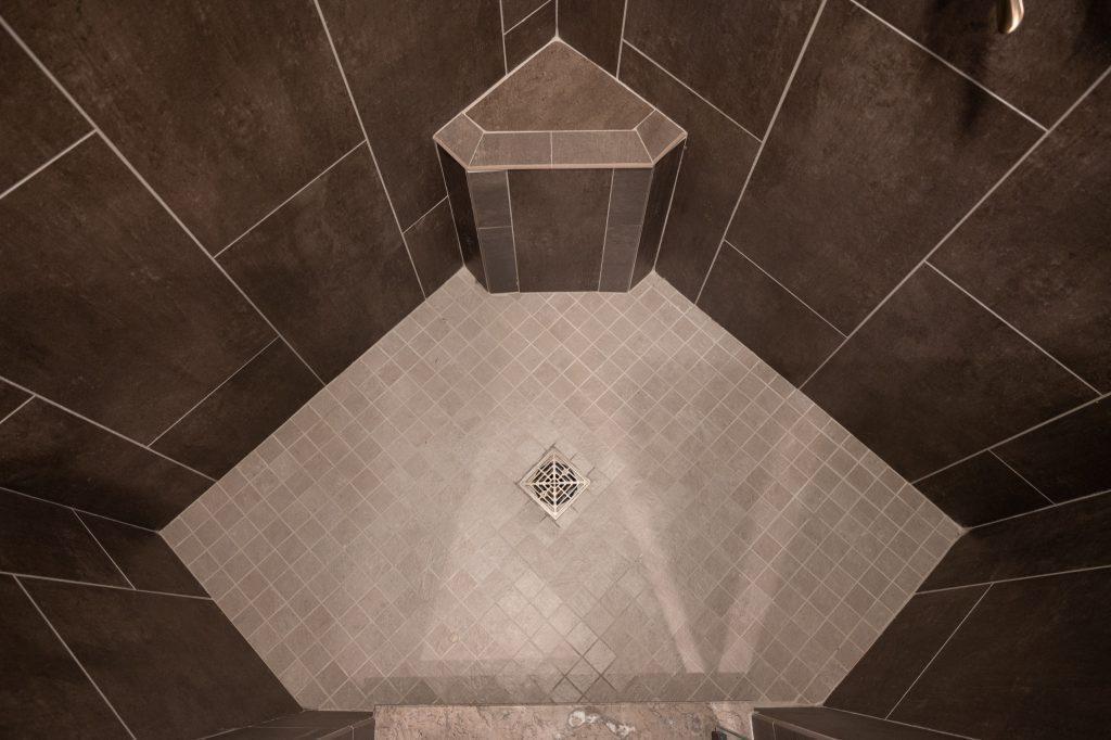 Arial view of the walk-in shower floor in a triangle shape along with small bench seat.