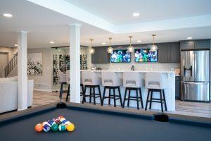 Finished basement pool table with bar and living room view in Northville, Michigan