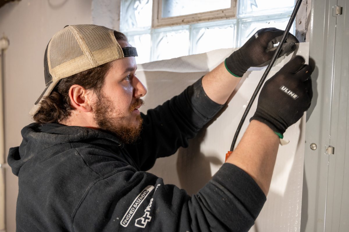 Photo of Basement's Plus technician installing waterproofing to a basement.